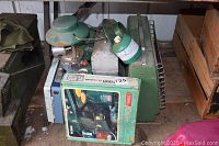 Lot of camping supplies including Coleman oven box, Primus stove, propane lantern, ammo box and lunch box.