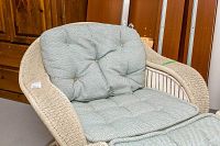 Close-up of tufted light blue-green cushion on the Ridpath's Tommy Bahama resin woven chair, showing texture and condition of cushions and woven frame.