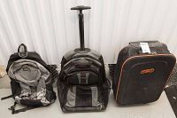 Front view of three luggage items: knapsack, medium wheeled suitcase with extended handle, and larger wheeled suitcase with TNT logo