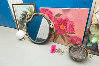 Photo showing three pieces of art and a round mirror framed with rope, plus some miscellaneous items in the foreground.