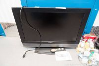 Insignia Harmony 32 inch flat screen TV with remote control and manual on the table