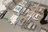 Overhead view of Wii remotes, Nunchuks, silicone jackets, wheels, cables, game cases