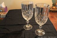 Two Waterford Crystal iced beverage glasses placed on black cloth showing cut design and shape.