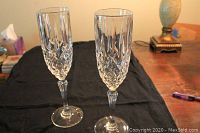 Two Waterford Crystal champagne flutes, showing the cut crystal detail on the bowls and slender stems.