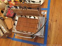 Photo showing Oster toaster oven, metal serving basket with wicker base stacked on top, and wicker magazine rack behind.