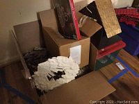 Overview of boxes containing white wreath and holiday garlands