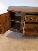 Photo showing left cabinet door open with two shelves inside, detailing wood grain and finish.