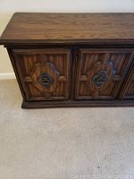 Front view of closed buffet showing two doors with carved geometric patterns and metal ring handles