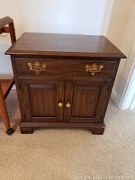 Front view of Penn House side table showing two cabinet doors and single drawer with brass hardware.