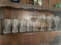 Shelf display showing 5 iced beverage tumblers and 5 Waterford crystal goblets with different cut patterns