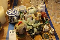 View of the whole lot showing all decor items on display including ceramic jars, shoe figurines, wooden bird, glass grapes, miniature tea set, and framed photo.