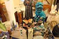 Overall view of the Asian themed decorative items including dragon statue, tall figure, butterfly-patterned boxes, carved figurines and seals on a table.