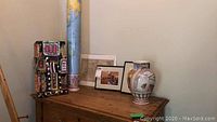 Photo of Tiffany & Co vase, framed wall art pieces and decorative art on wood surface