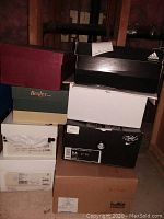 Stack of nine shoe boxes showing various brands and box colors
