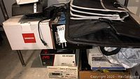 Photo shows stacked boxes including JVC, Pioneer, Sangean, and Cambridge Audio boxes, with black automotive carrier bags on top.