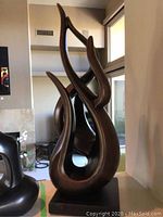Front view of brown abstract swirl sculpture on rectangular base