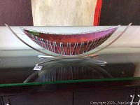 Full front view of glass art piece on metal stand