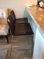 Two stools positioned side by side at kitchen counter showing seat height and leg design