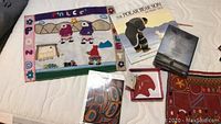 First photo shows a fabric wall hanging with Indigenous figures and symbols, two Indigenous themed books including 'The Polar Bear Son', and a small red pendant in a box.