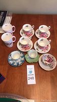 Full view of all tea cups, saucers and mugs on wooden table