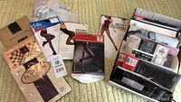 Overview of various pantyhose packages and some loose pantyhose on a bed.