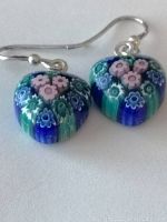 Close-up of the front side of the heart-shaped Murano glass earrings showing detailed Millefiori floral patterns in blue, green, and pink colors
