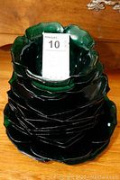 Stacked flower-shaped green dinner plates, salad plates, and bowls with label Mikasa handcrafted by Kurata visible.