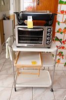 Full view of the lot showing the KitchenAid toaster oven on the cart with the Presto electric roaster on top.