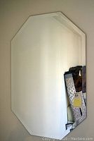 Front view of the octagonal beveled wall mirror hanging on a light-colored wall, showing reflective surface and shape clearly.