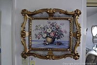 Front view showing ornate gold frame and floral painting of flowers in vase