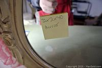 Close-up of mirror corner with taped note indicating dimensions of 72 x 2 x 40 inches