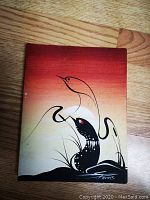 Front view of Indigenous oil on canvas painting "Young Loons" showing stylized loon imagery with gradient red to cream background and artist signature visible in bottom right corner with date 2003.