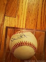 Side view of the baseball showing Devon White's autograph and stitching.