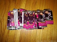 Front view of multiple sealed 1995/96 Upper Deck Cool Rookie hockey card wax packs in purple foil wrapping lying on a wooden floor.