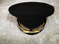 Front view of black air pilot captain's hat showing gold embroidered laurel on visor.