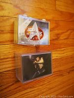 Photo showing the top view of two plastic cases containing the complete card sets, one for Star Trek The Next Generation and one for Final Fantasy.