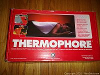 Photo of unopened red box showing Thermophore Classic branding and image of person using the heat therapy pad on the back.
