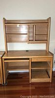 Front view of wooden desk with top hutch showing shelves and compartments