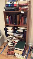 Front view of particle board wood bookcase filled with various books and items showing structure and condition