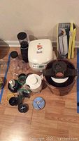 Overview of lot items including rice cooker, grinder, ice cream maker, vacuum sealer box and Magic Bullet parts
