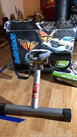 In Stride folding cycle with visible pedals, adjustable knob, and base stabilizers in front of Rollerblade box with butterfly decoration.