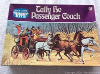 The front of the model kit box showing artwork of the Tally Ho Passenger Coach with four horses and coachmen, measuring approximately 14 inches in width with a tape measure for scale.