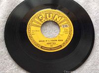 Vinyl record with visible label showing Sun Records logo and song title.