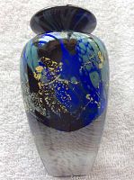 Front view of art glass bud vase showing deep blue, black, and gold leaf pattern with flared rim