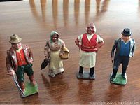 Photo of four standing antique hand-painted lead figurines with distinct details.