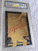 Front view of the 1996-97 Skybox EX-2000 Michael Jordan Credentials Signature Series card showing an embossed gold design with red signed autograph, graded 10 Gem Mint by WCG in a clear slab.