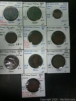 Lot of 10 British India coins mounted in plastic holders with detailed handwritten notes including dates, denominations, KM catalog numbers, metal type and condition.
