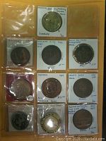 Photo showing a collection of commemorative medals and a button in individual plastic/cardboard holders with labels detailing their origin, including Sudbury Exceptional Service Enquiry Medal and Toronto City Hall First Visit Medal.