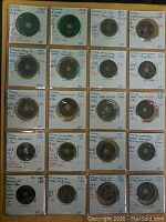 Photo showing 20 ancient Chinese coins in individual holders with handwritten labels denoting dates from 960 to 1394 AD.