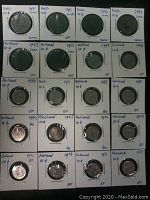 Collection of Holland 10 cent coins from 1941 to 1979 displayed in labeled cardboard holders indicating year and condition.